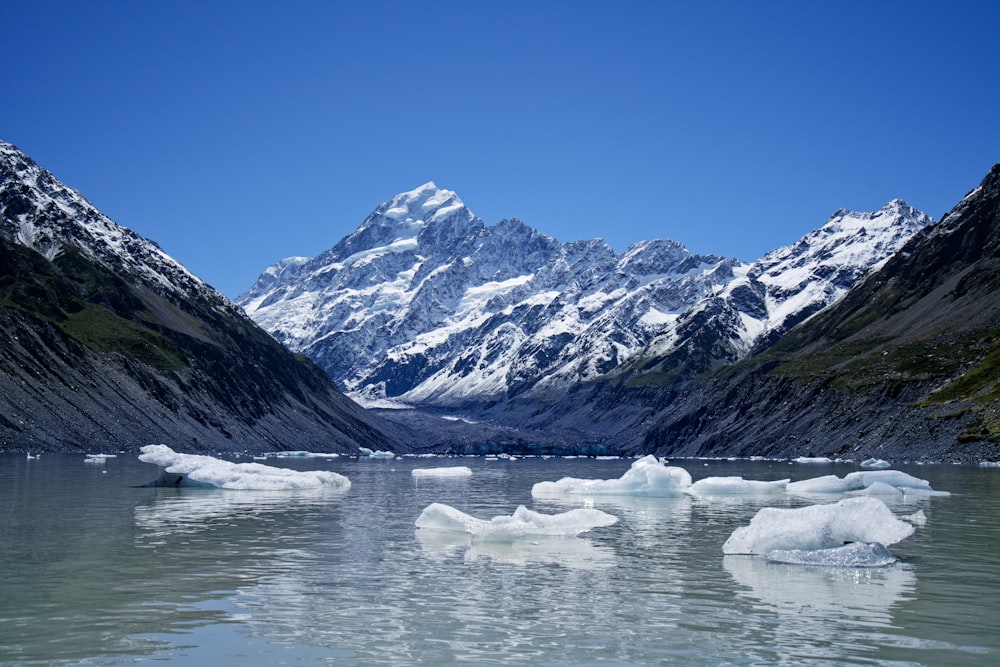 a group of icebergs floating on top of a lake