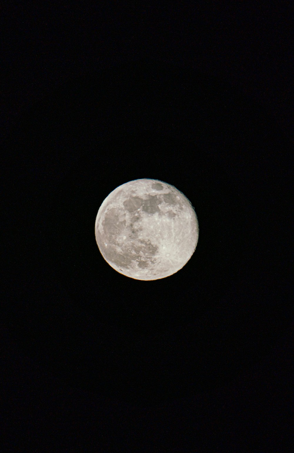 a full moon is seen in the dark sky