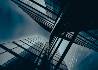 Indeva Research corporate hero banner showing modern glass skyscraper buildings
