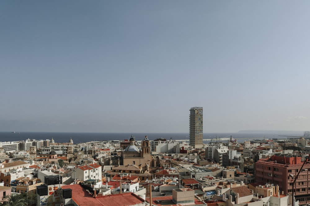 Blick auf eine Stadt mit hohen Gebäuden und dem Meer im Hintergrund