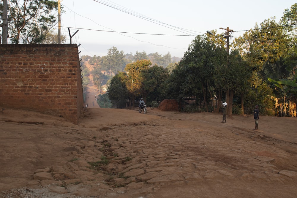 a dirt road with people riding bikes on it