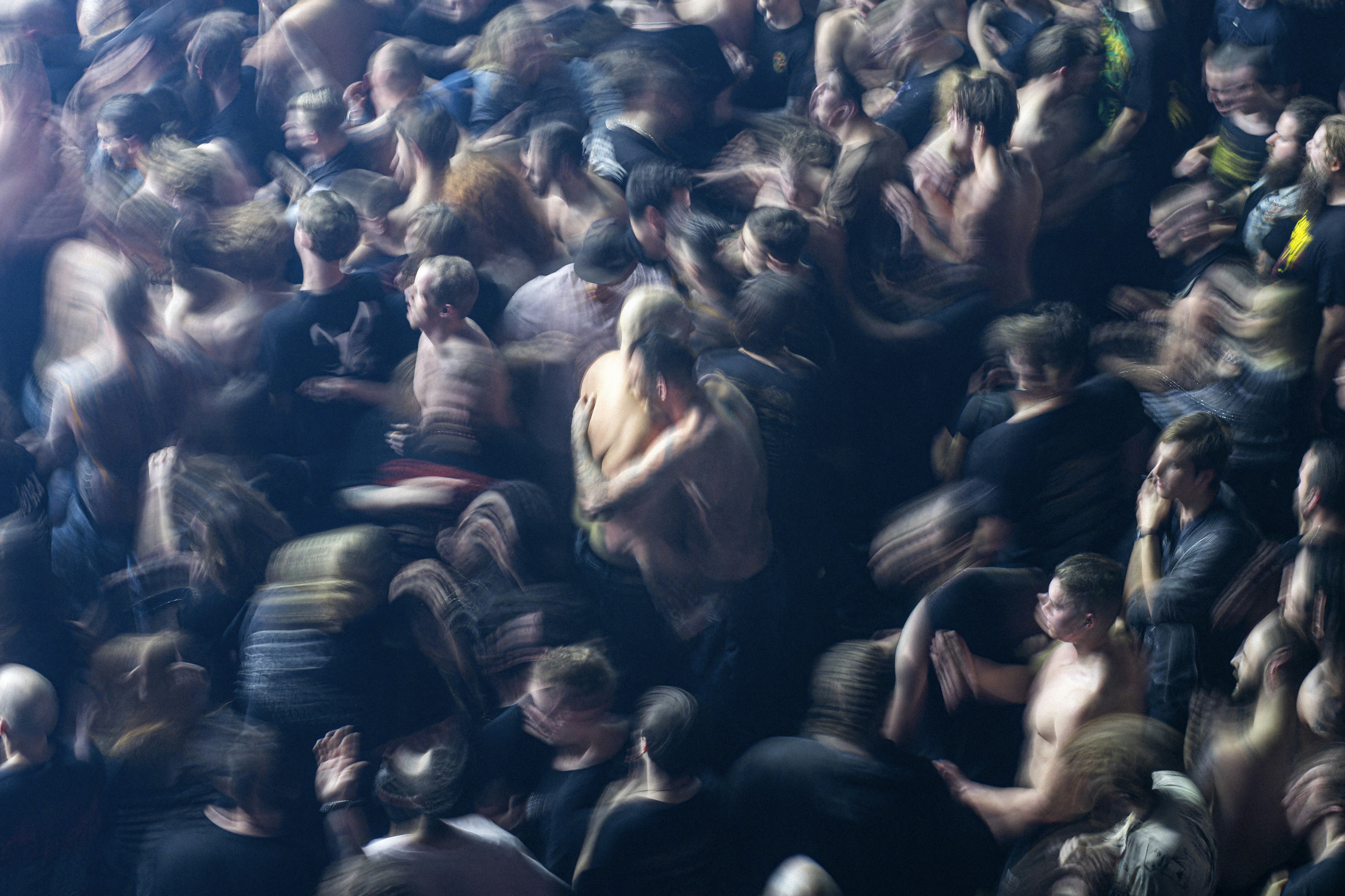 a crowd of people standing around each other, A moshpit crowd at a heavy metal music concert