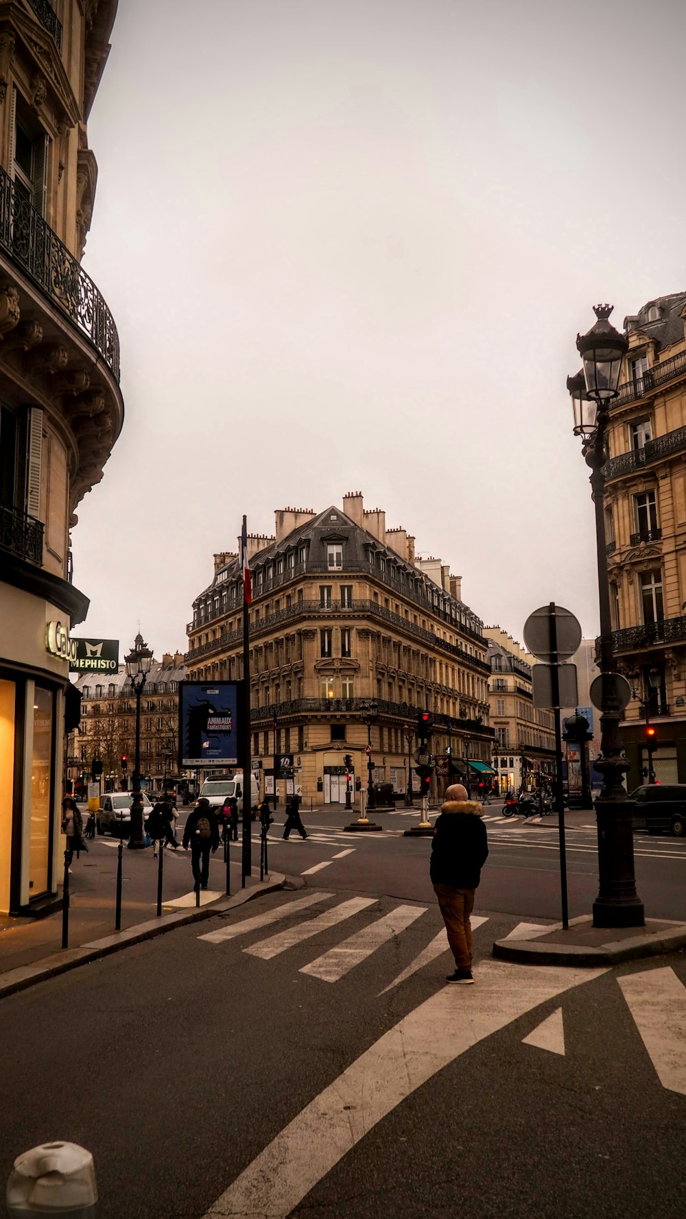 a woman walking down a street next to tall buildings