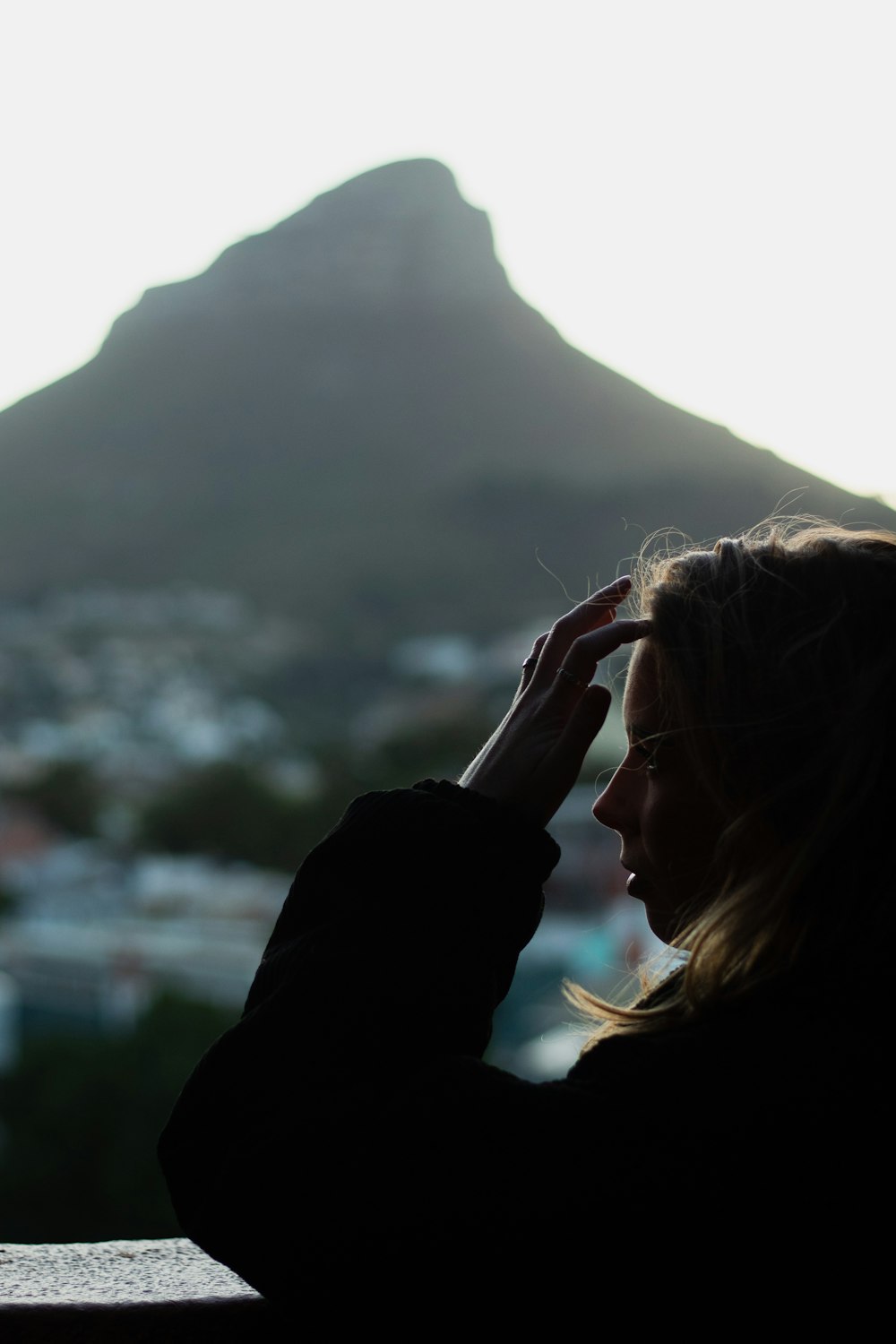 a woman looking out a window at a mountain
