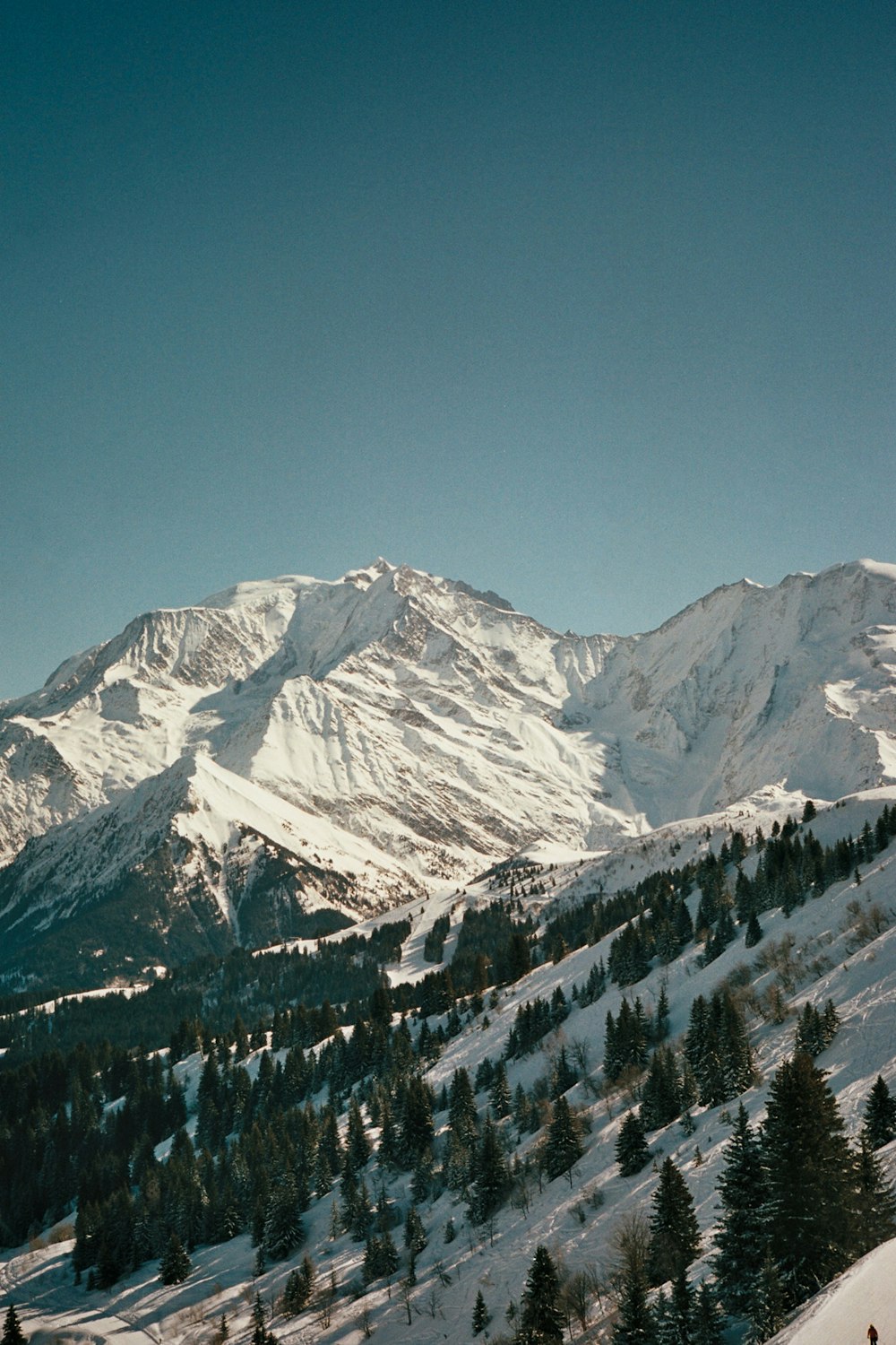 a person riding skis on top of a snow covered slope