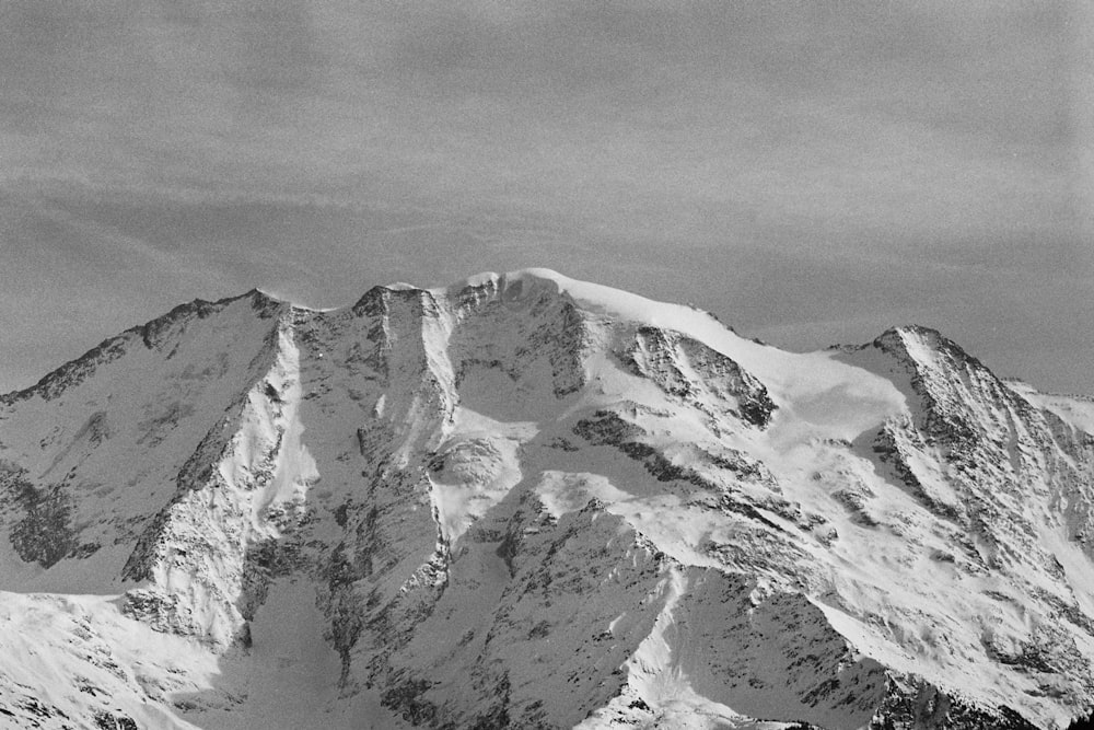 a black and white photo of a snow covered mountain