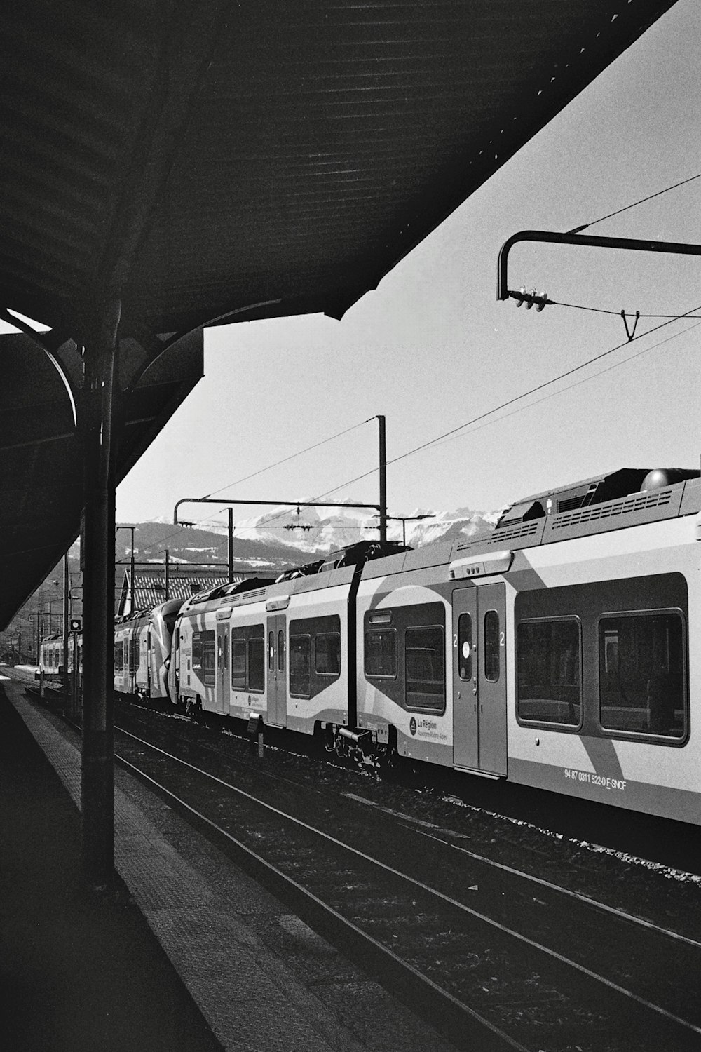 ein Schwarz-Weiß-Foto eines Zuges an einem Bahnhof