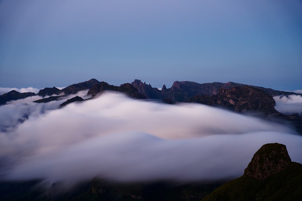 a view of a mountain range covered in clouds