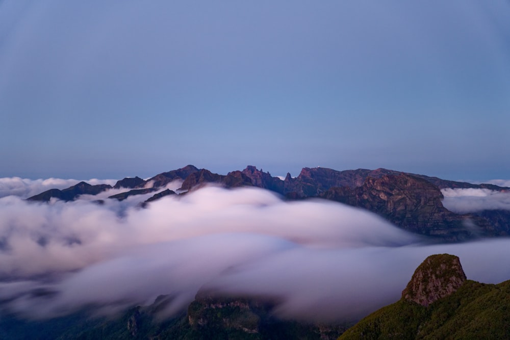 a view of a mountain range covered in clouds