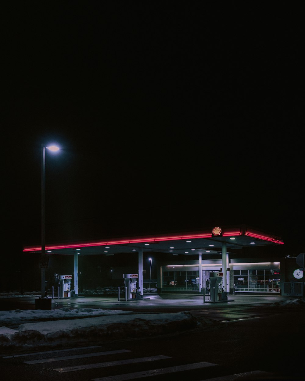 a gas station lit up at night time