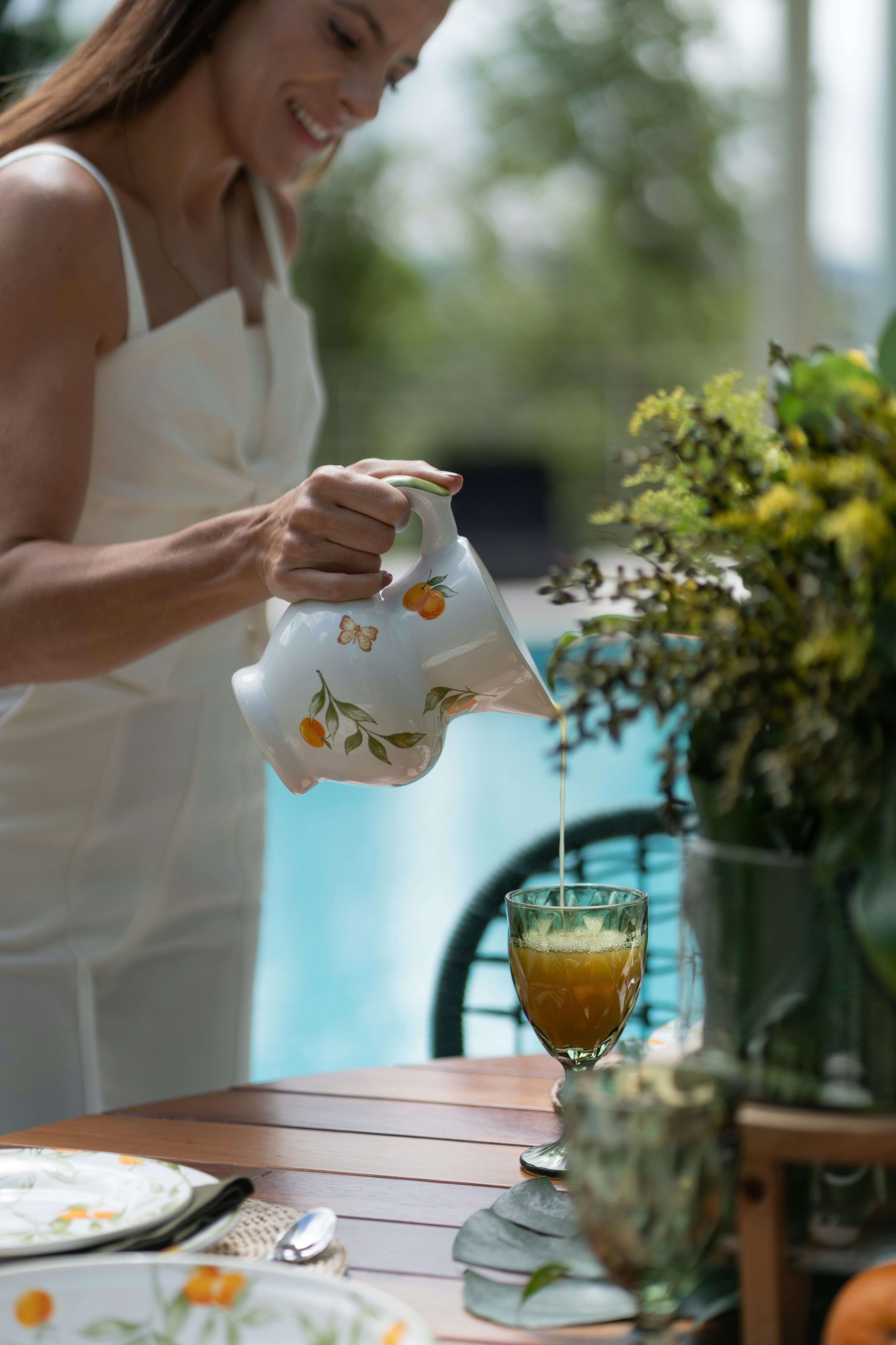 a woman pours a cup of tea from a teapot