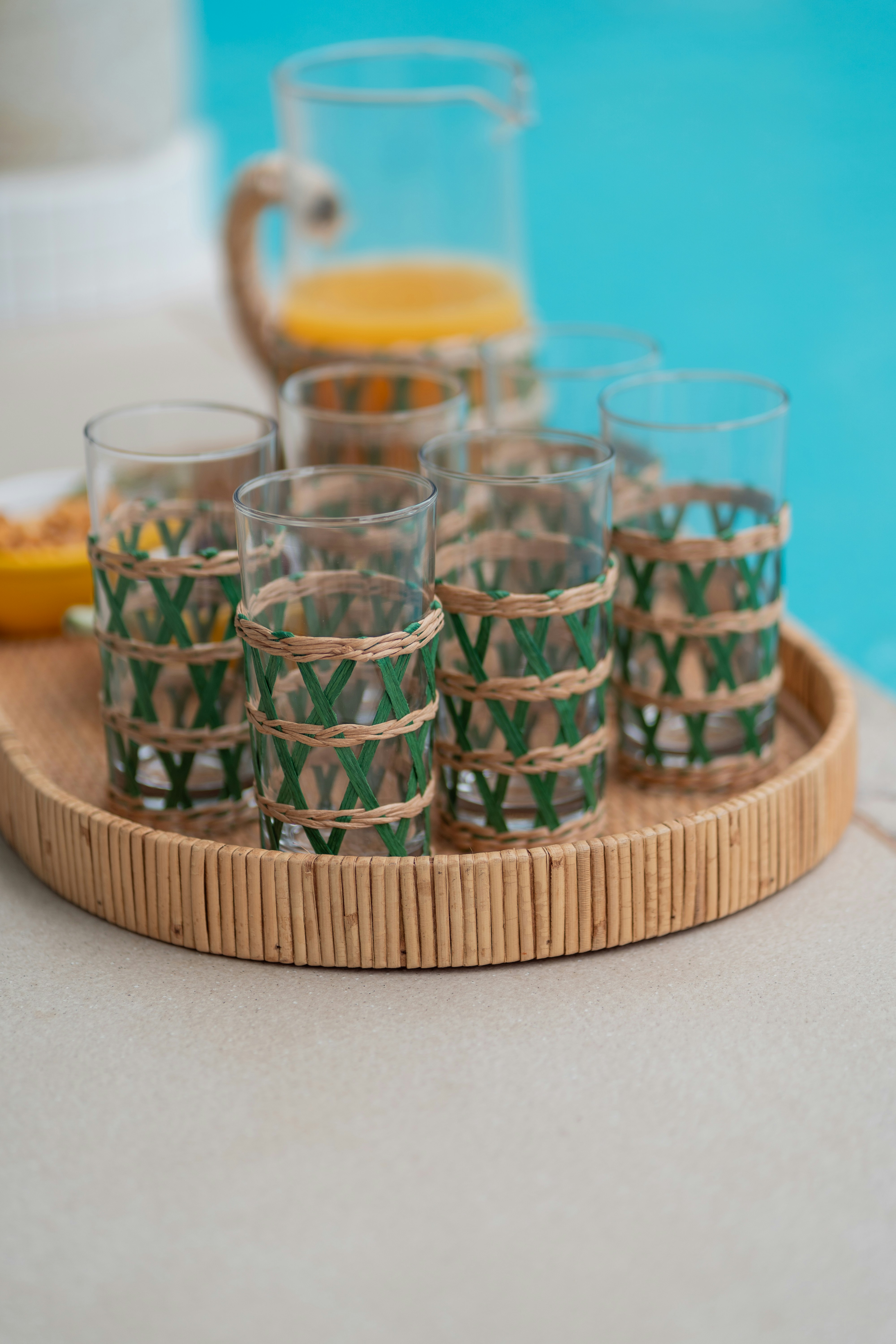 a tray of glasses sitting on a table next to a pool