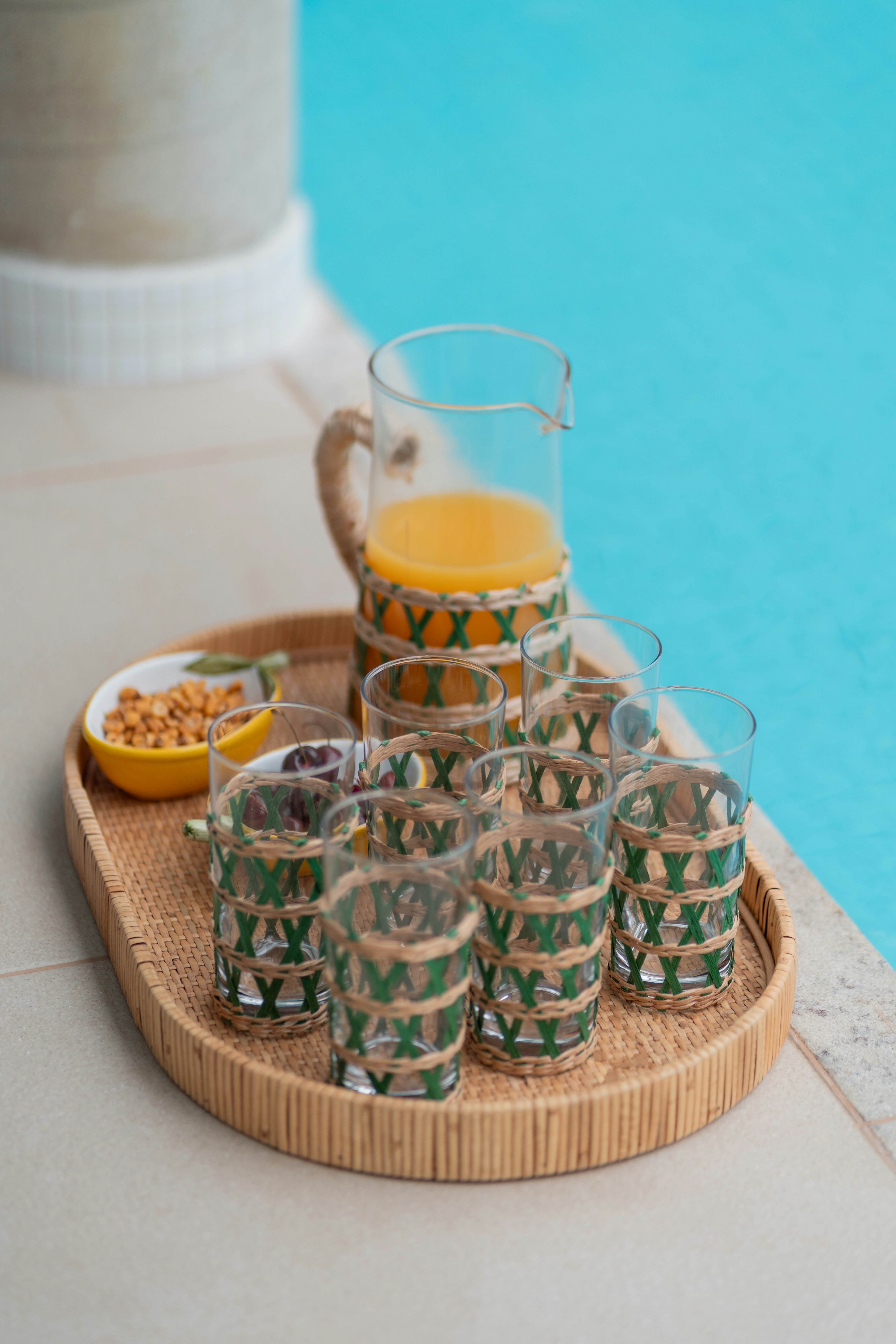 a tray of glasses next to a swimming pool