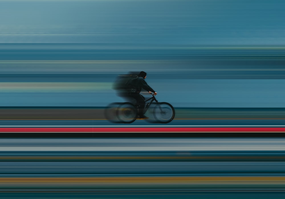 una foto sfocata di una persona in sella a una bicicletta