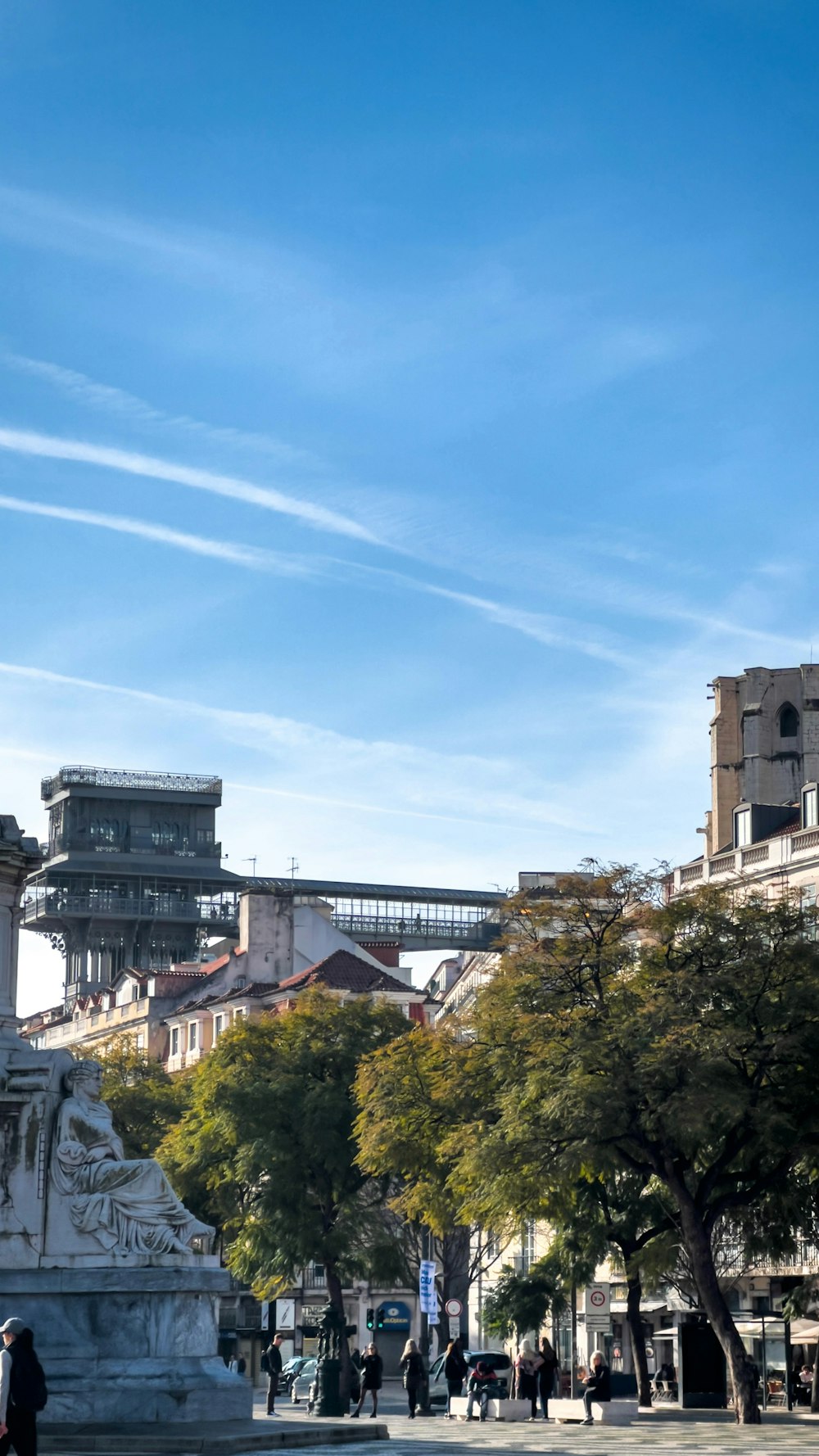 une statue dans un parc avec un pont en arrière-plan