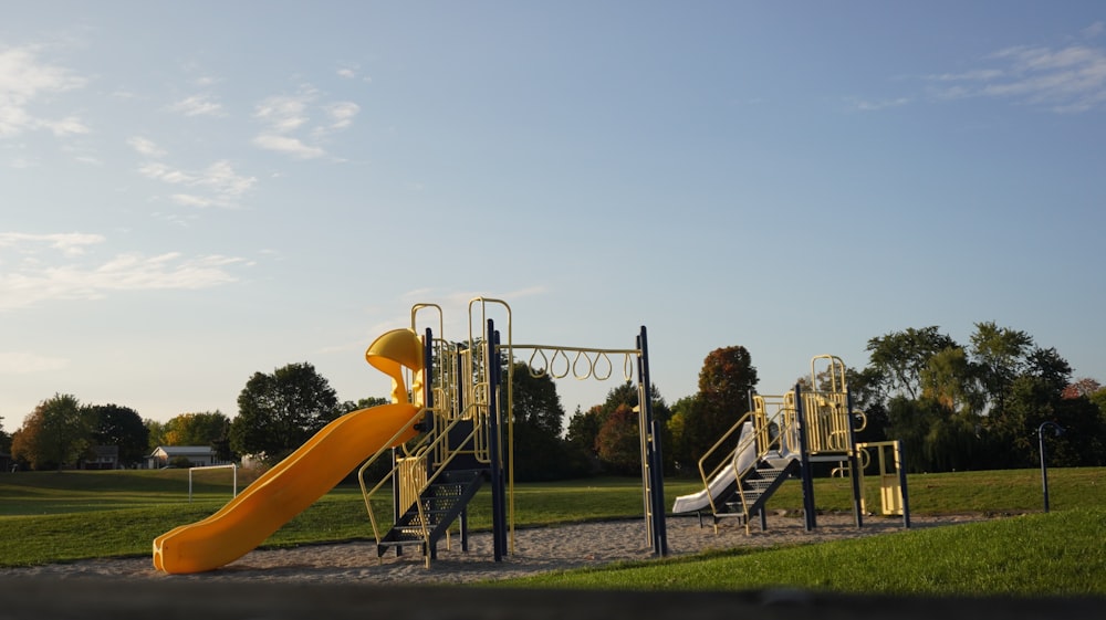 un parque infantil con un tobogán amarillo y un tobogán amarillo