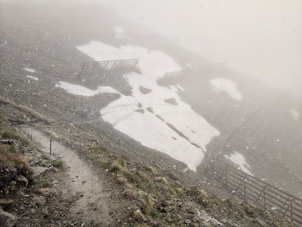 a snow covered mountain with a wooden fence