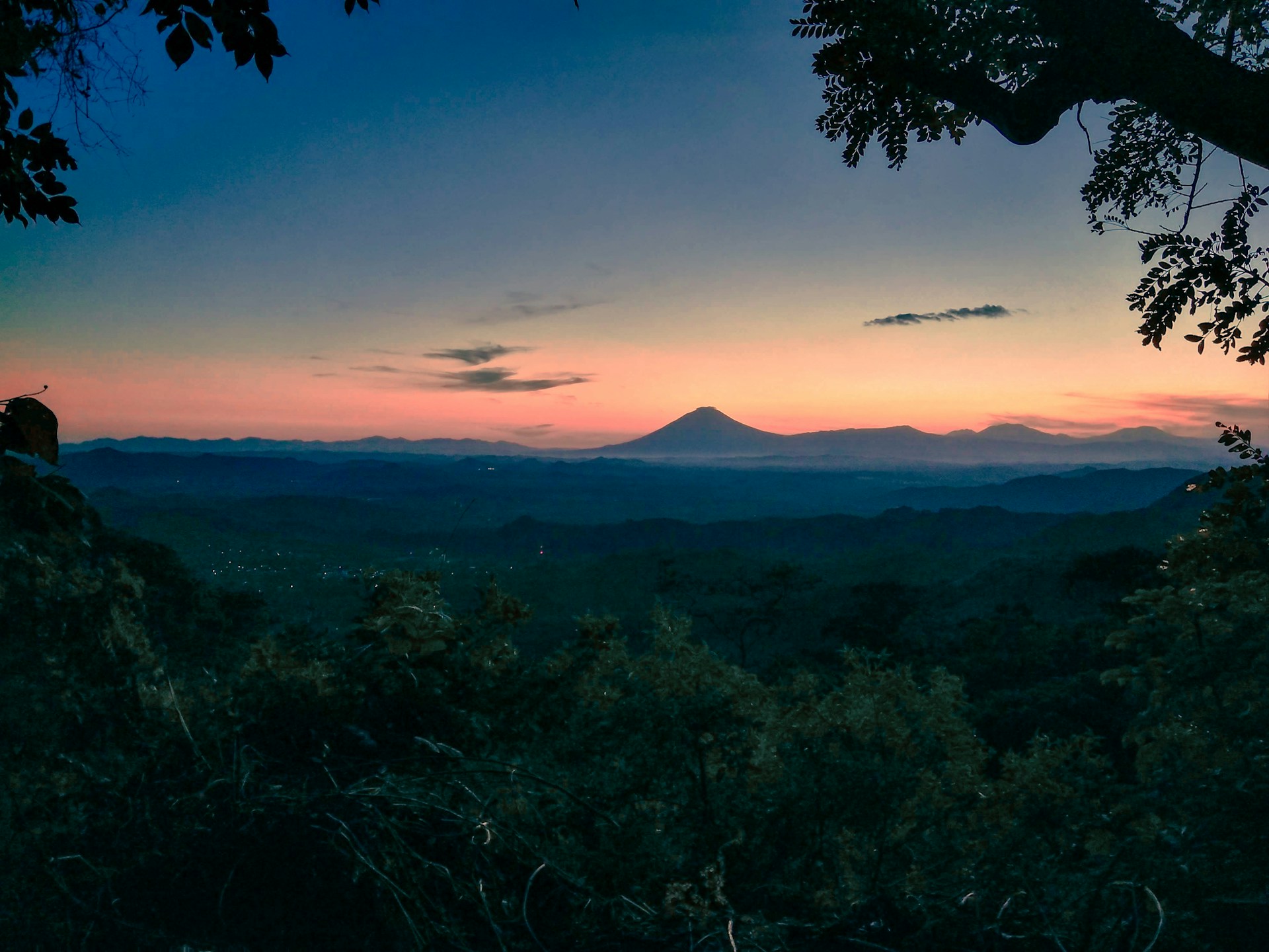 the sun is setting over a mountain range