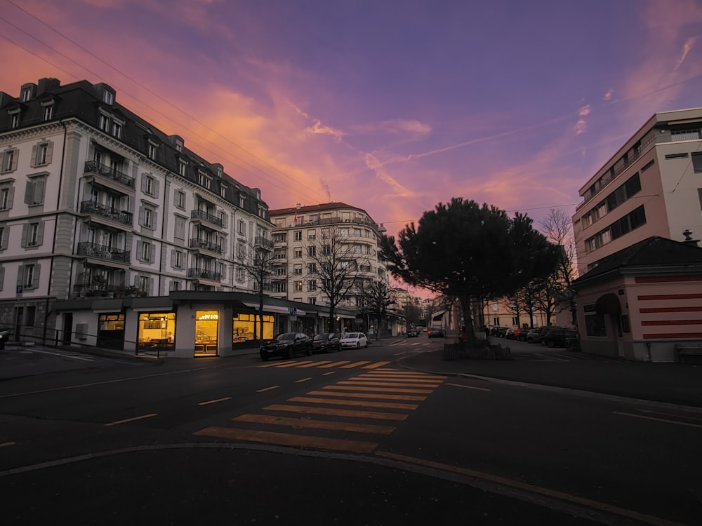 a city street at sunset with buildings in the background