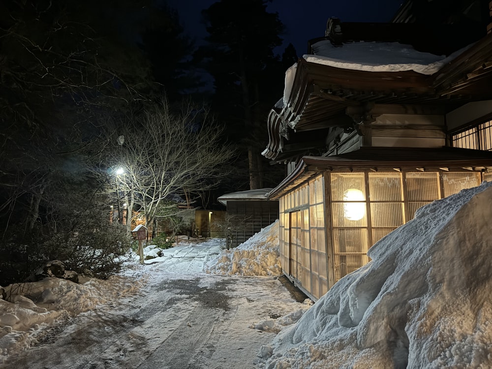 a snow covered path leading to a building at night