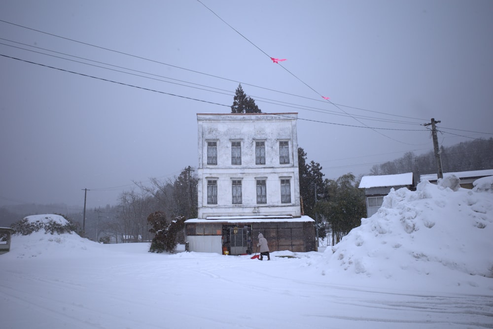 a large white building sitting in the middle of a snow covered street