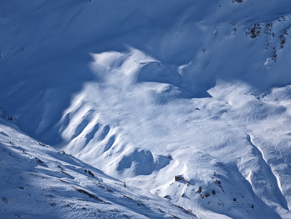 a snow covered mountain with a person skiing down it
