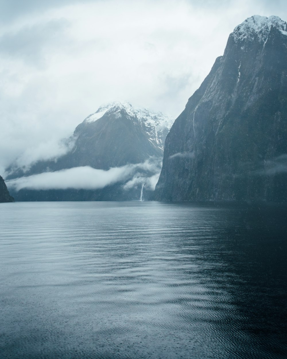 a body of water with mountains in the background