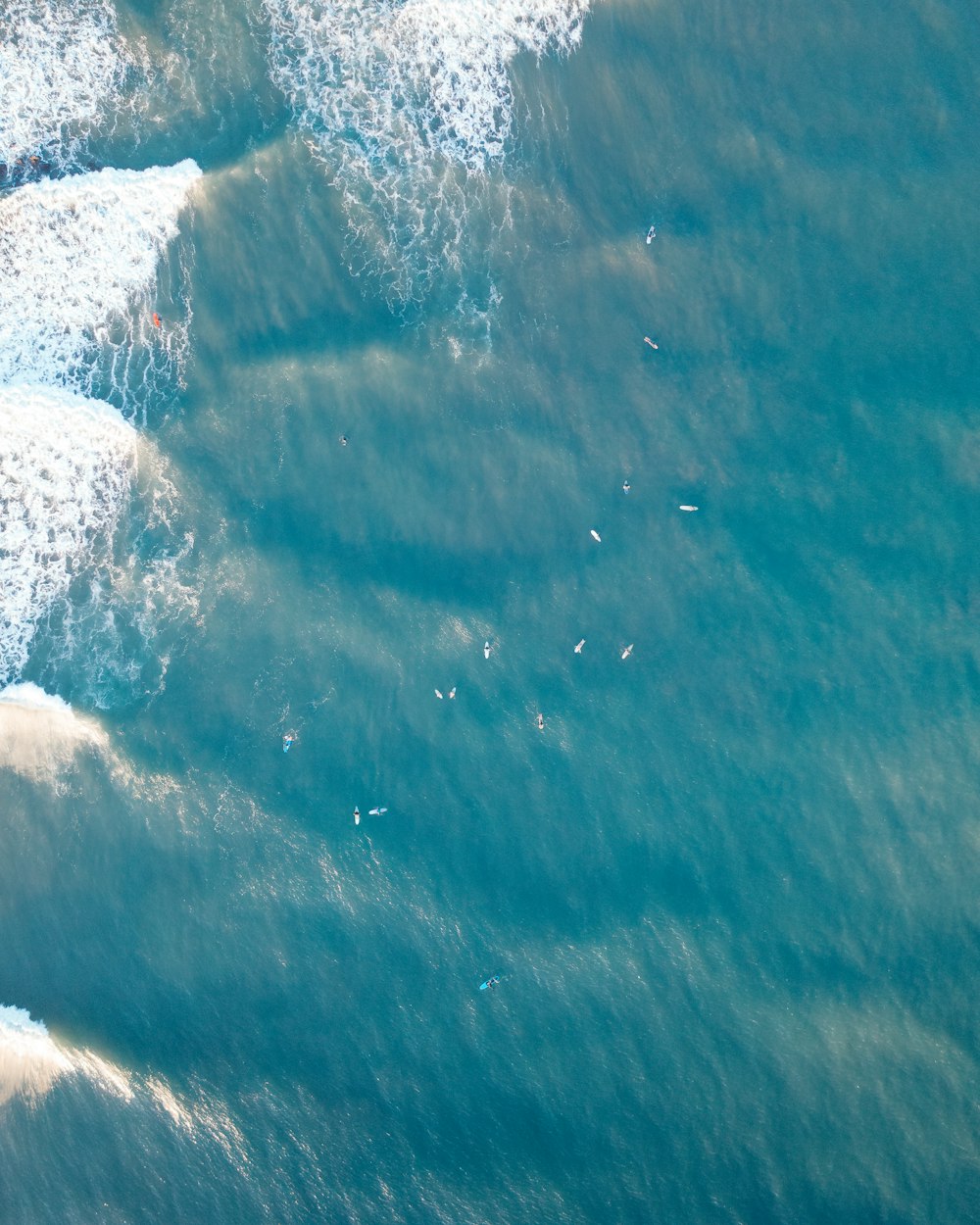 a group of people riding waves on top of surfboards