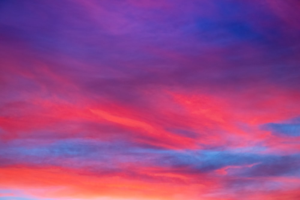 a red and blue sky with some clouds