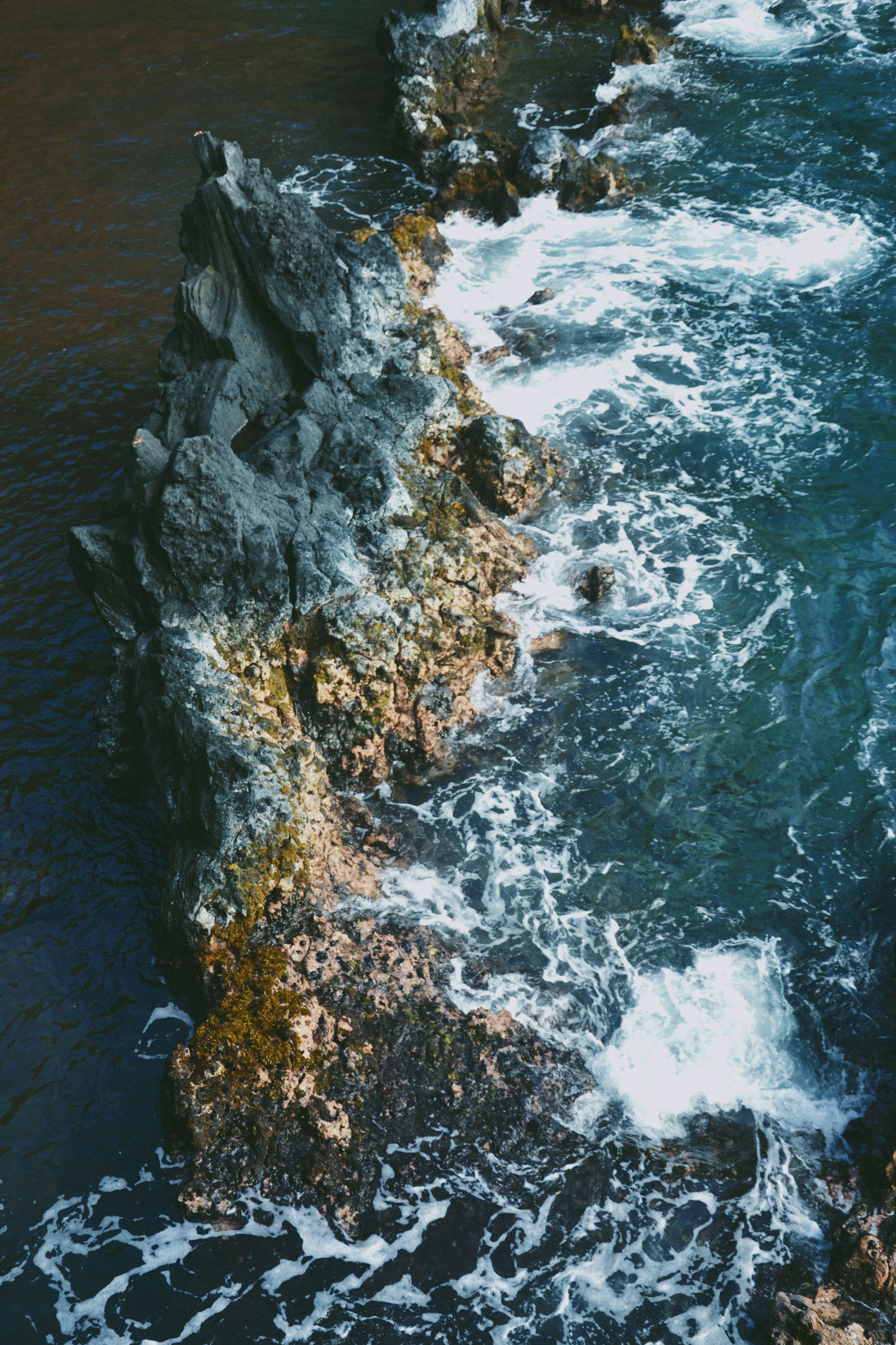 a couple of rocks sitting on top of a body of water