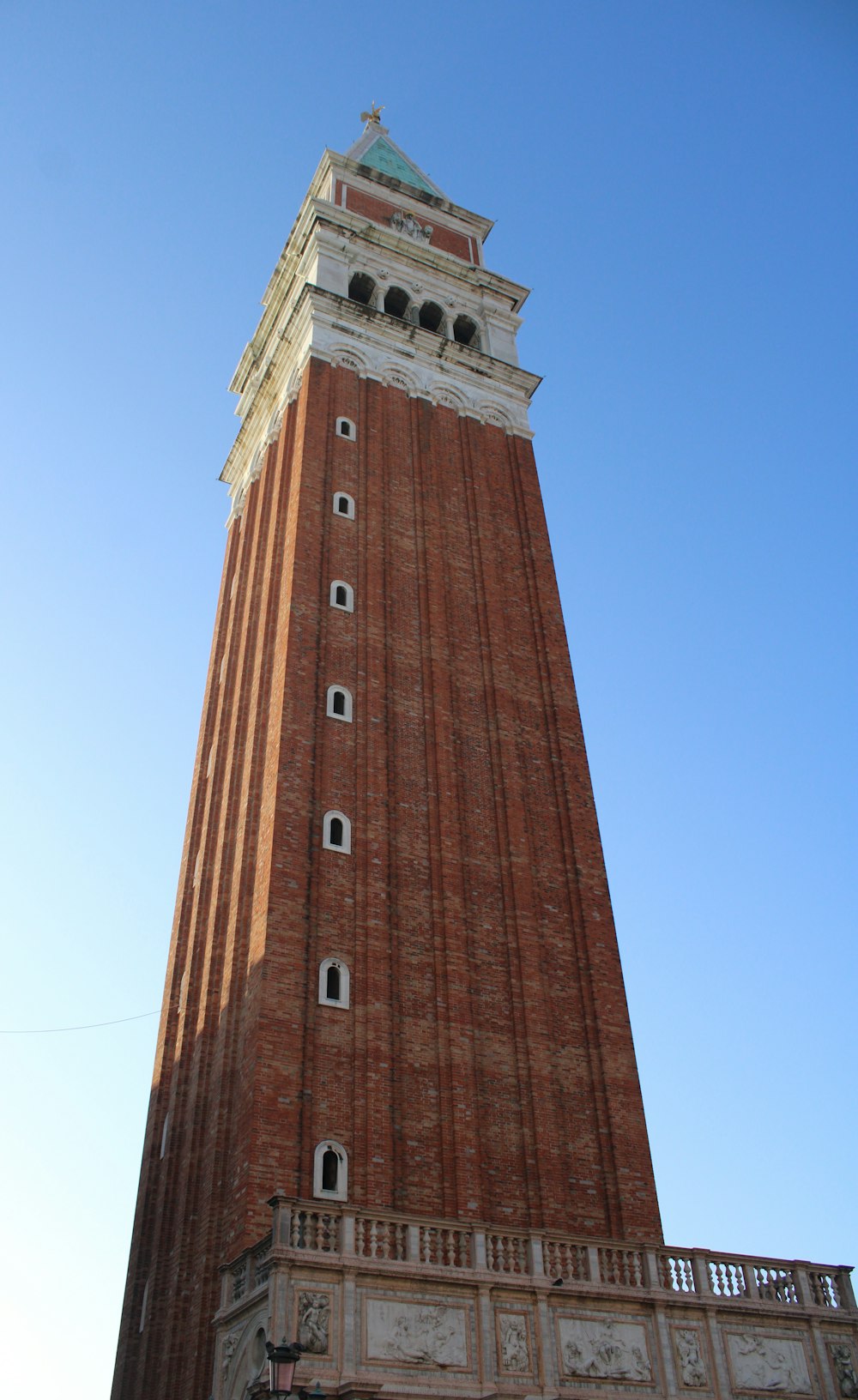 un'alta torre di mattoni con un orologio in cima