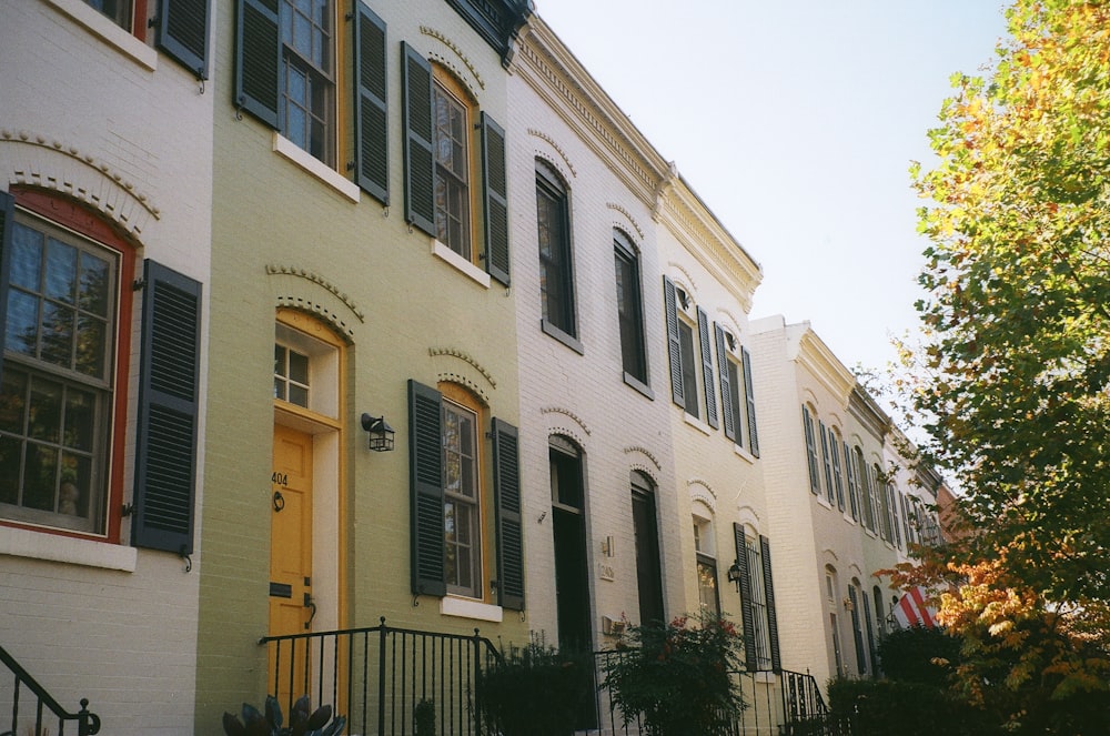 a row of houses with yellow doors and windows