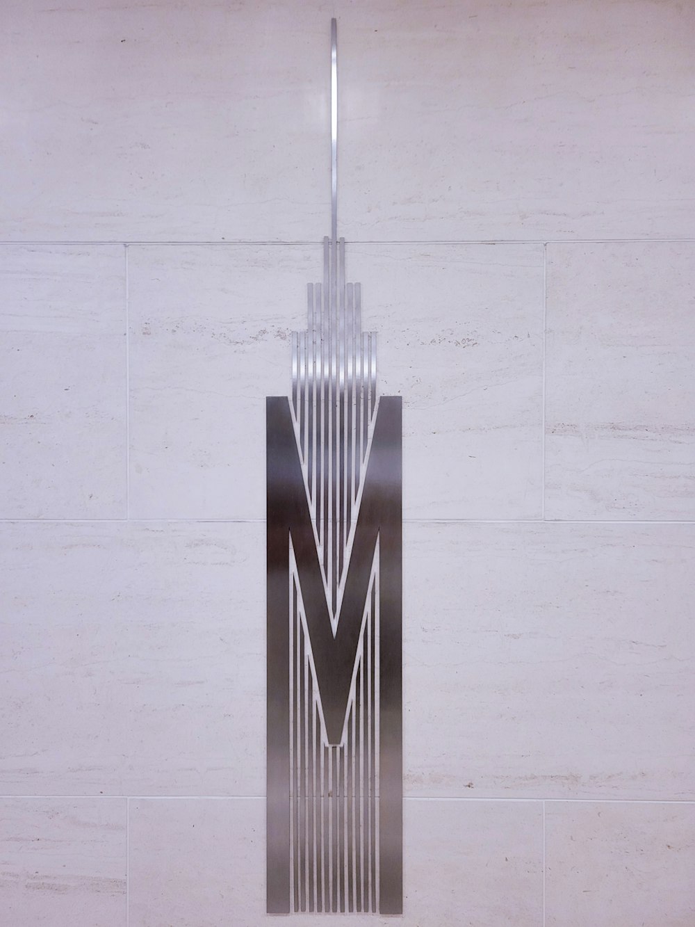a metal sculpture with the letter m on it