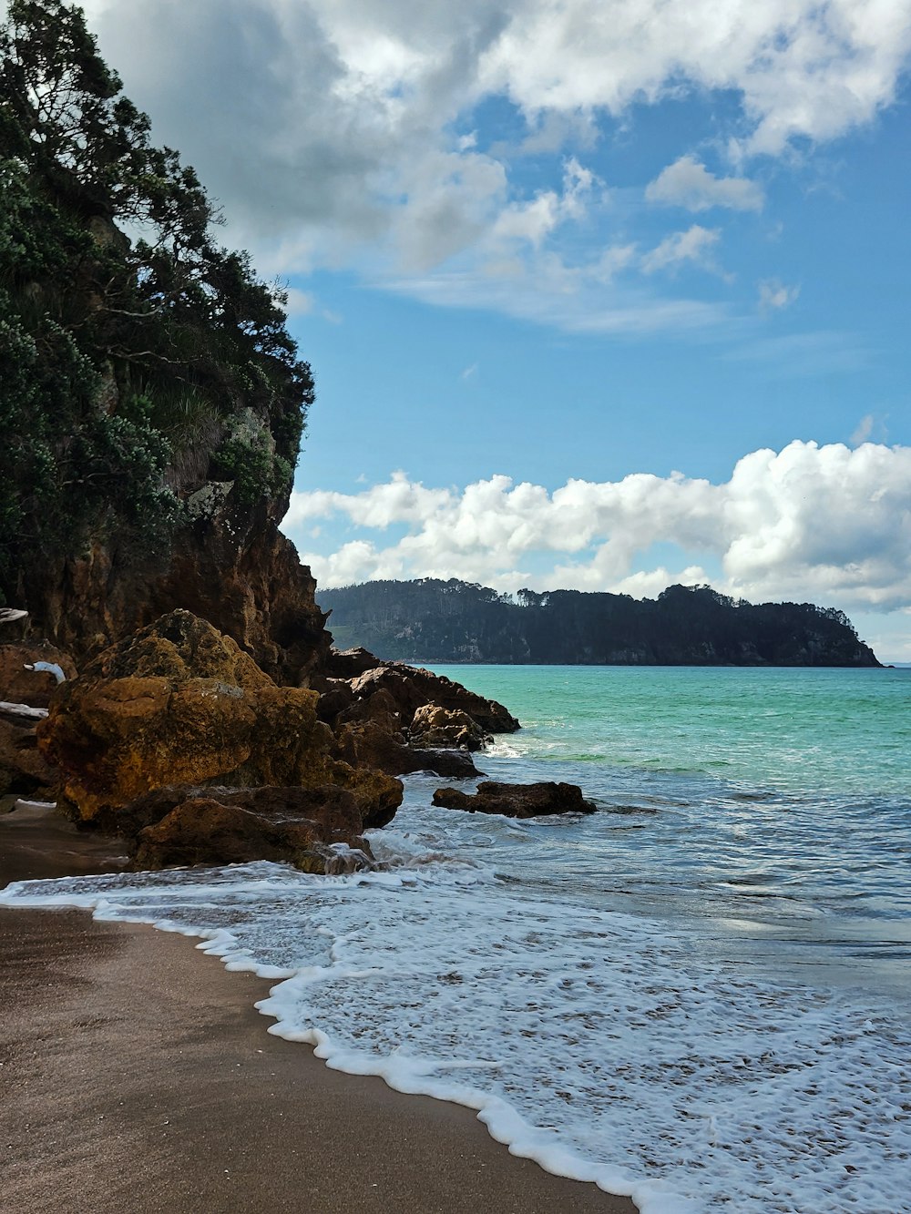 a sandy beach with waves coming in to shore