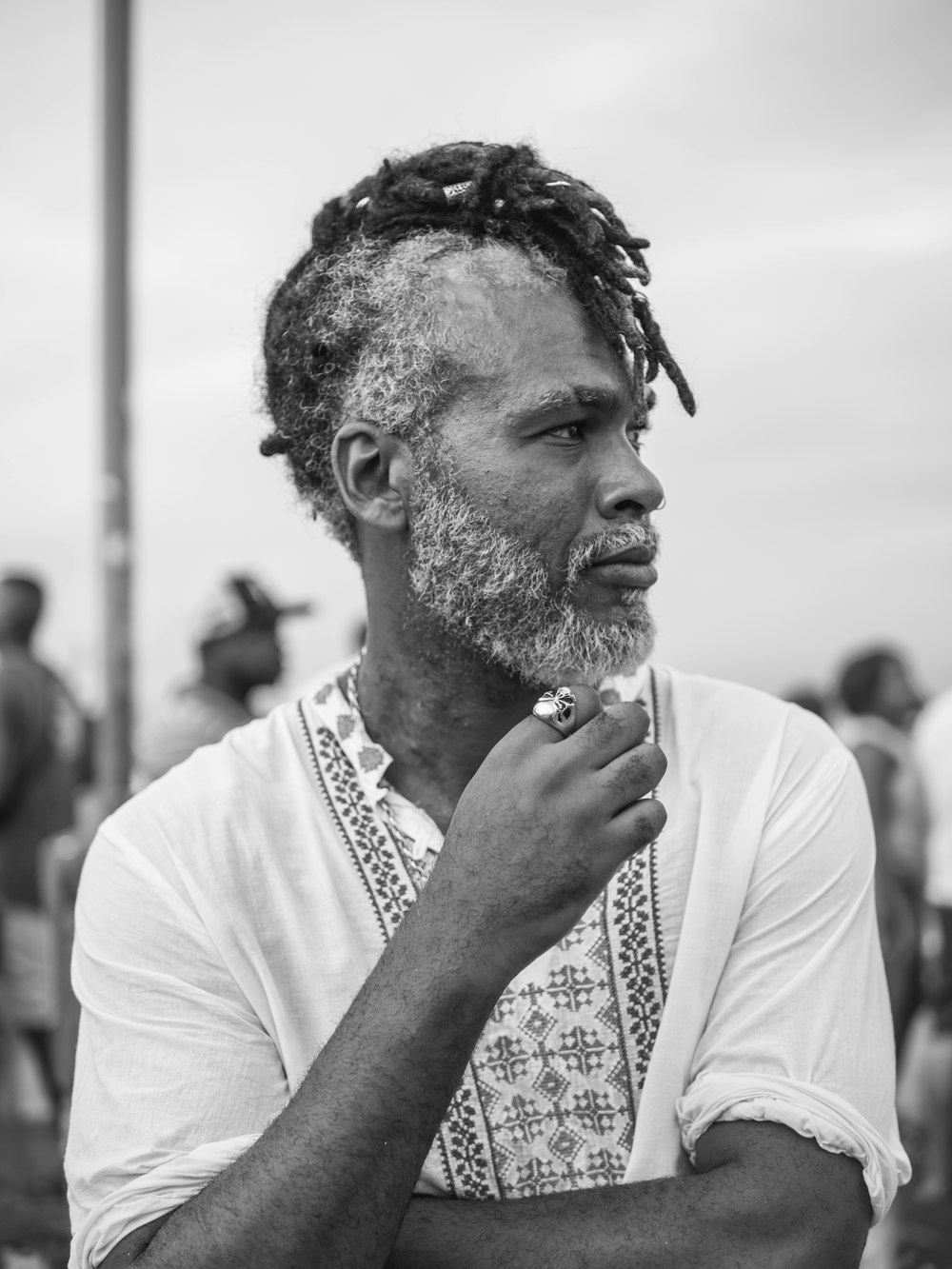 a black and white photo of a man with dreadlocks