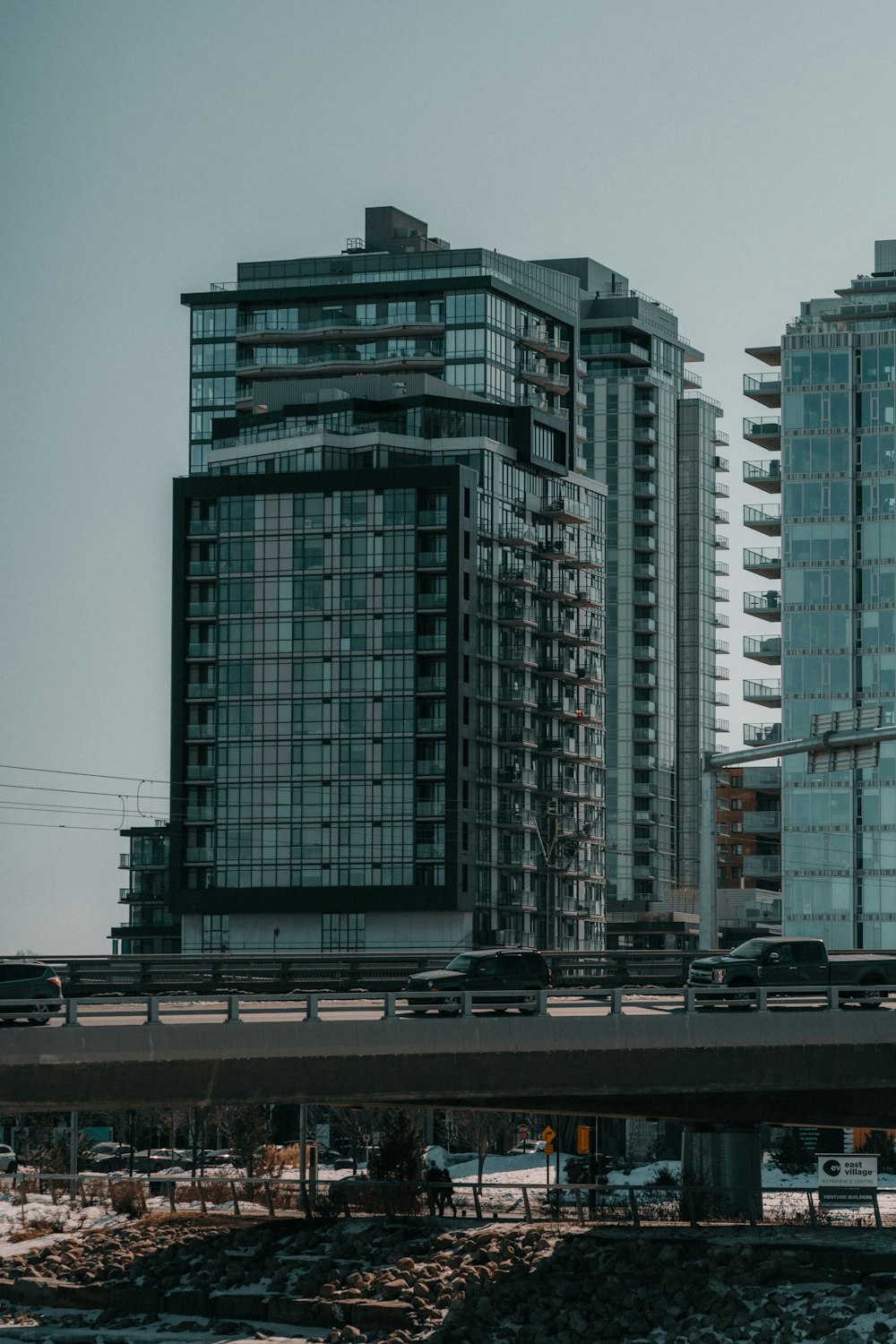 a train traveling past tall buildings on a bridge