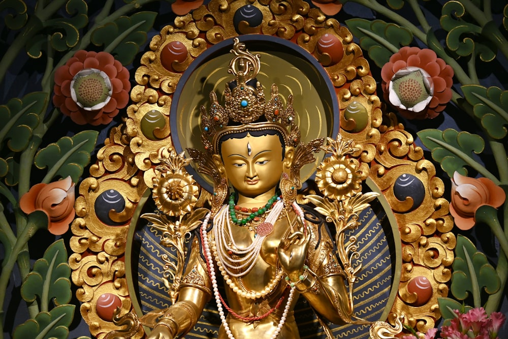 a golden statue of a person surrounded by flowers