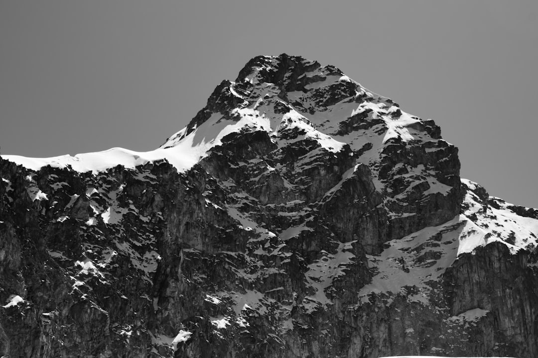 a black and white photo of a snow covered mountain,