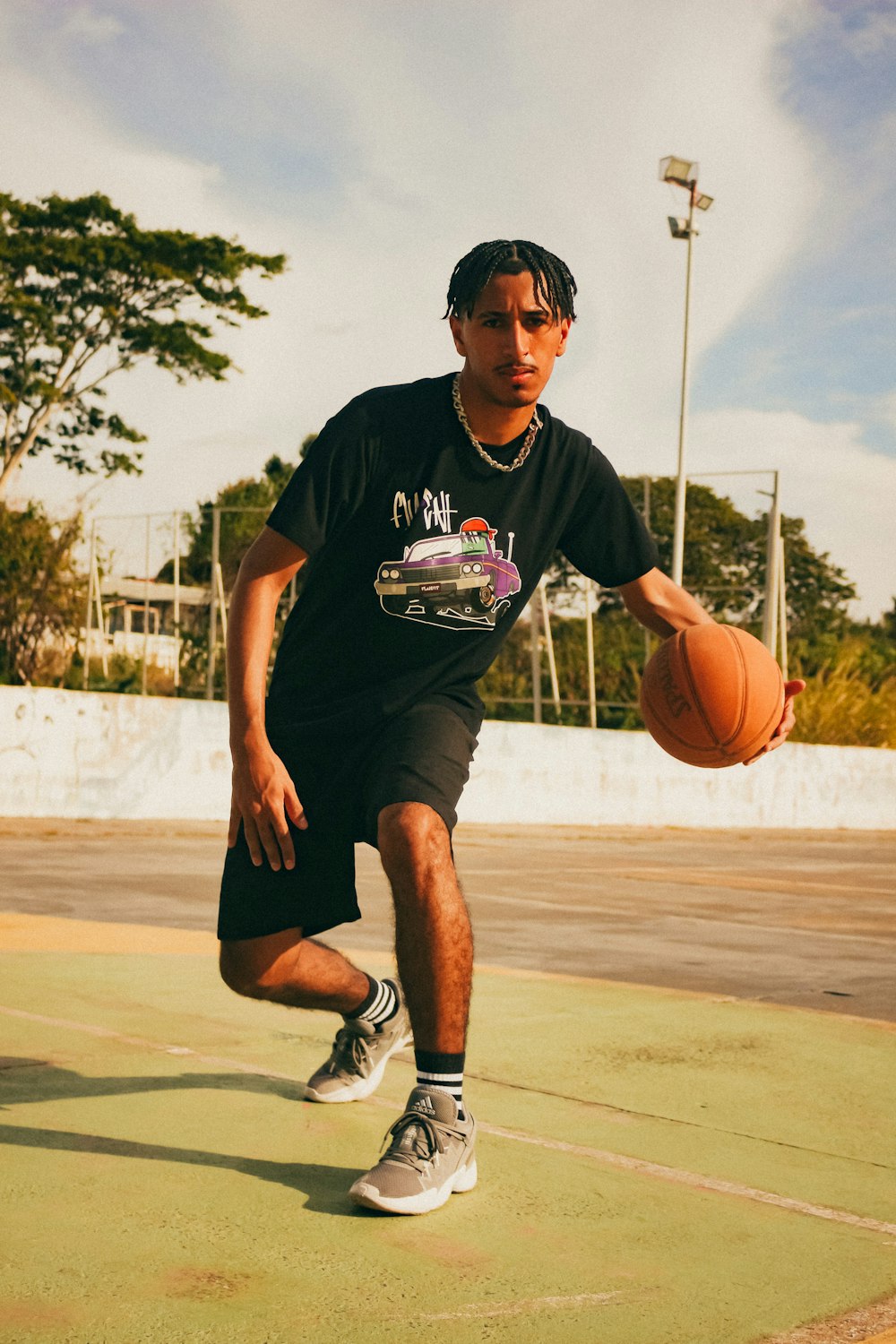 a man holding a basketball on top of a basketball court