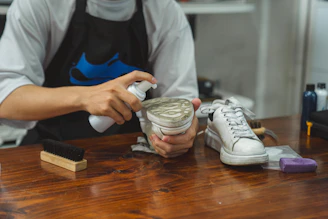 a person with a shoe polishing a pair of shoes