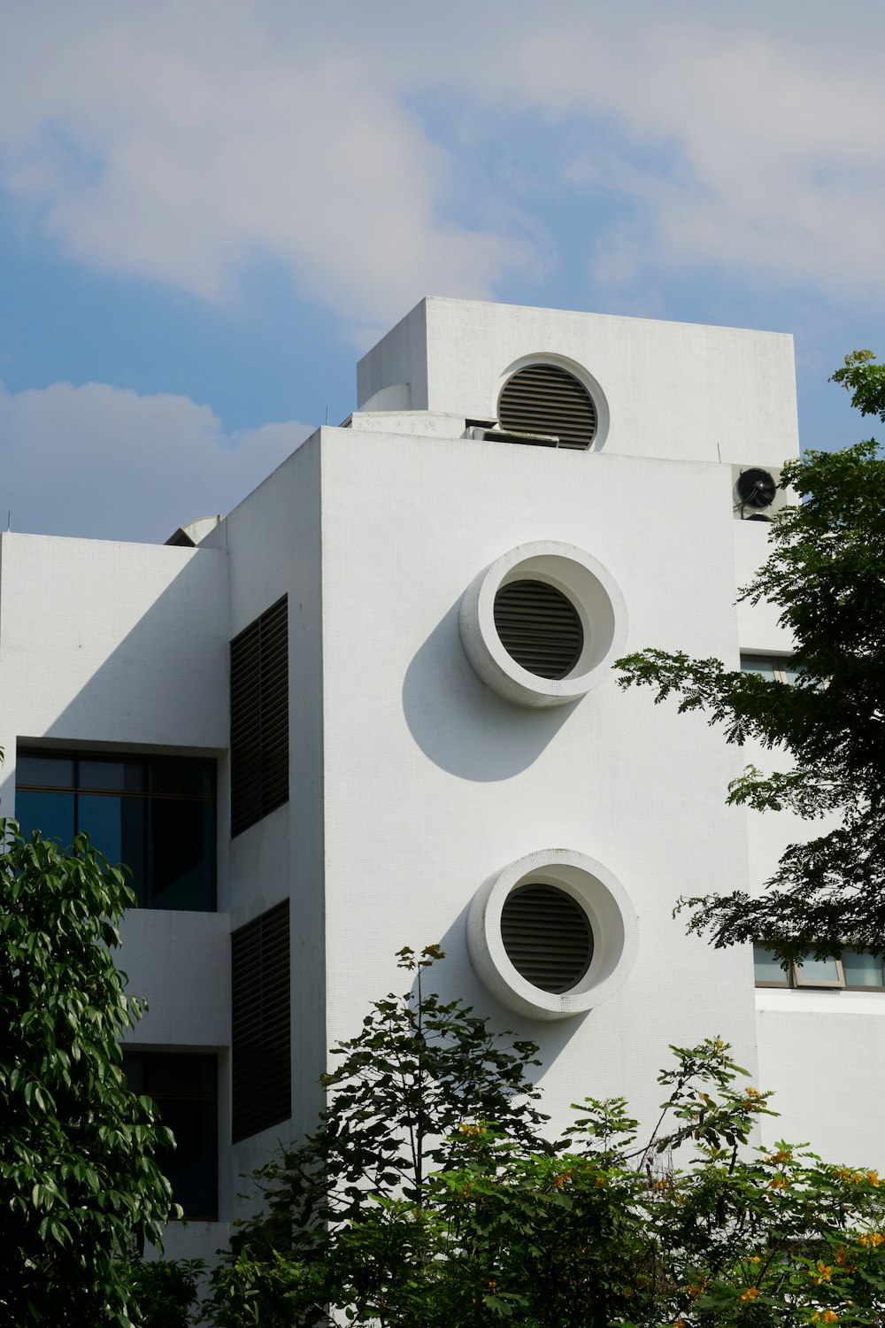 a white building with three round windows on the side of it
