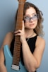 a woman wearing sunglasses holding a guitar