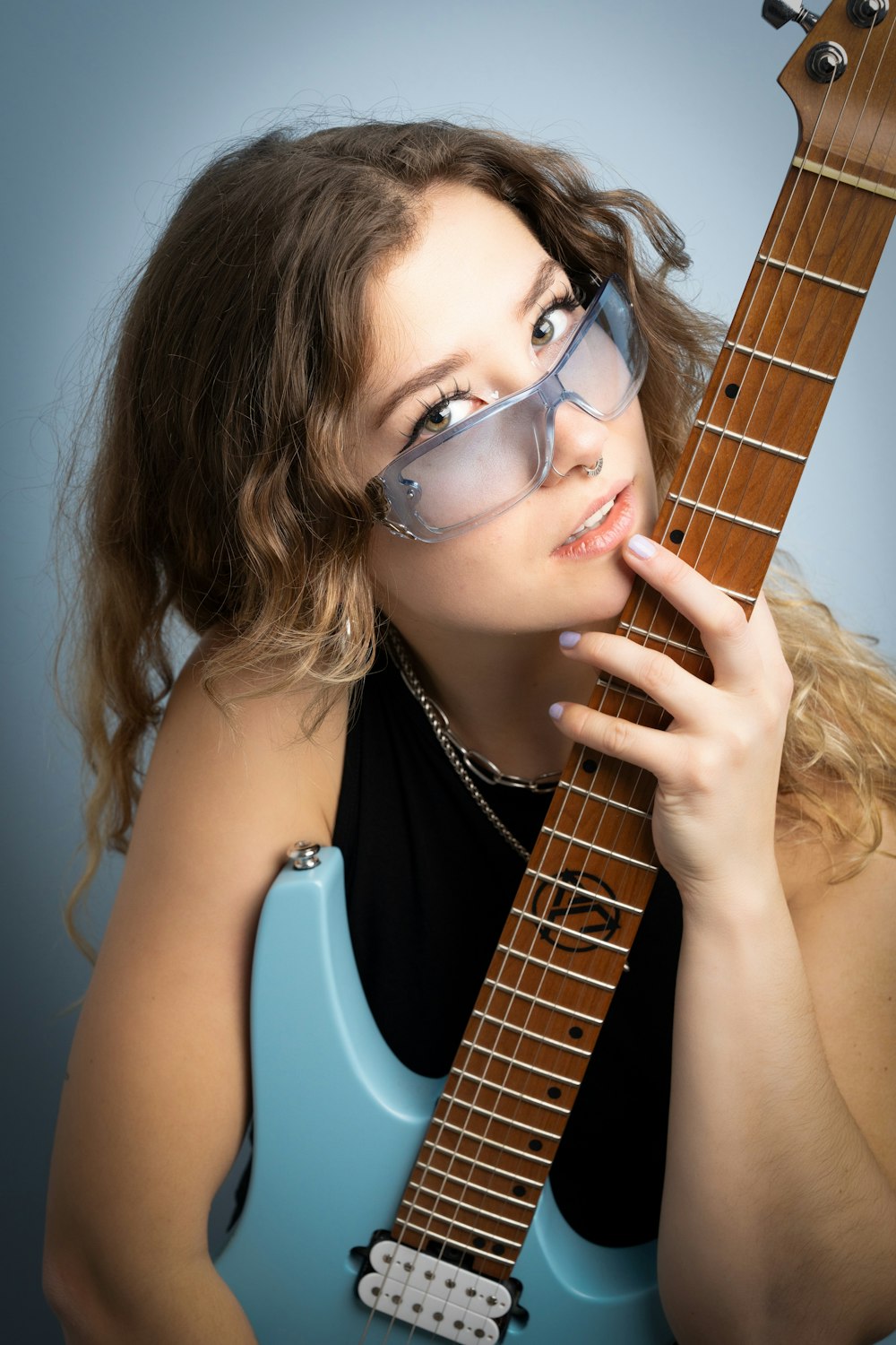 a woman with glasses holding a guitar