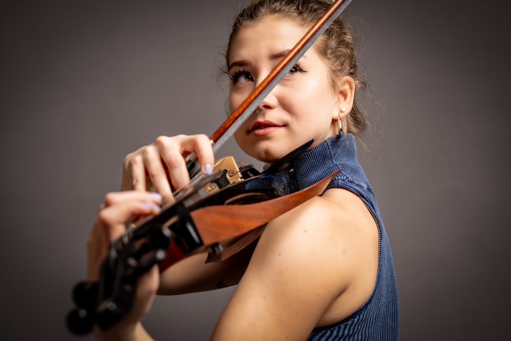 a young woman holding a violin in her right hand