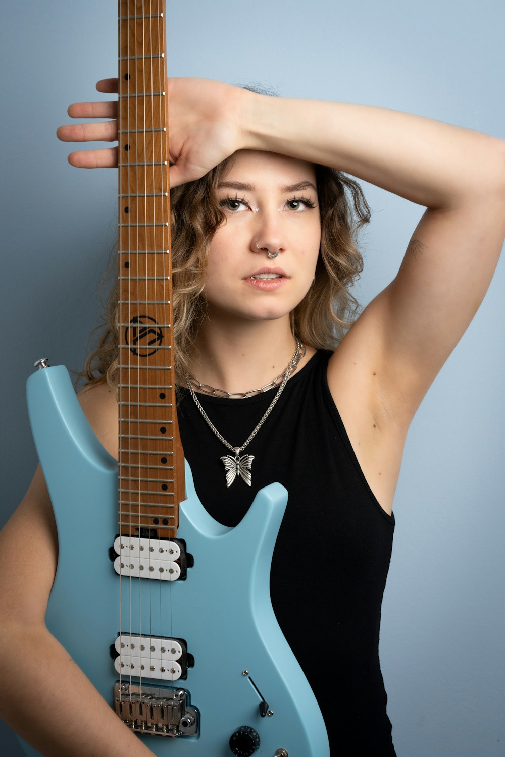 a woman holding a blue guitar in front of her face