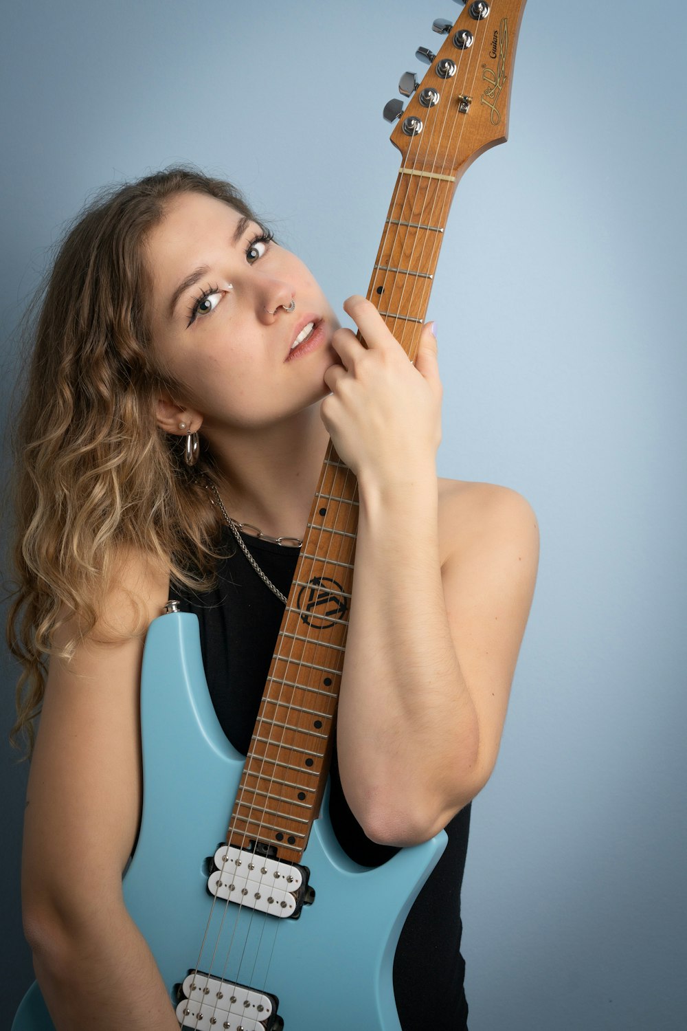 a woman holding a guitar up to her face