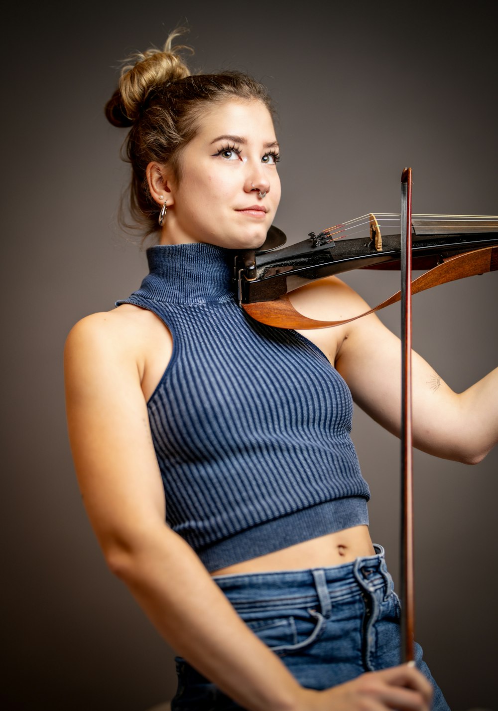 a woman is holding a violin and posing for a picture