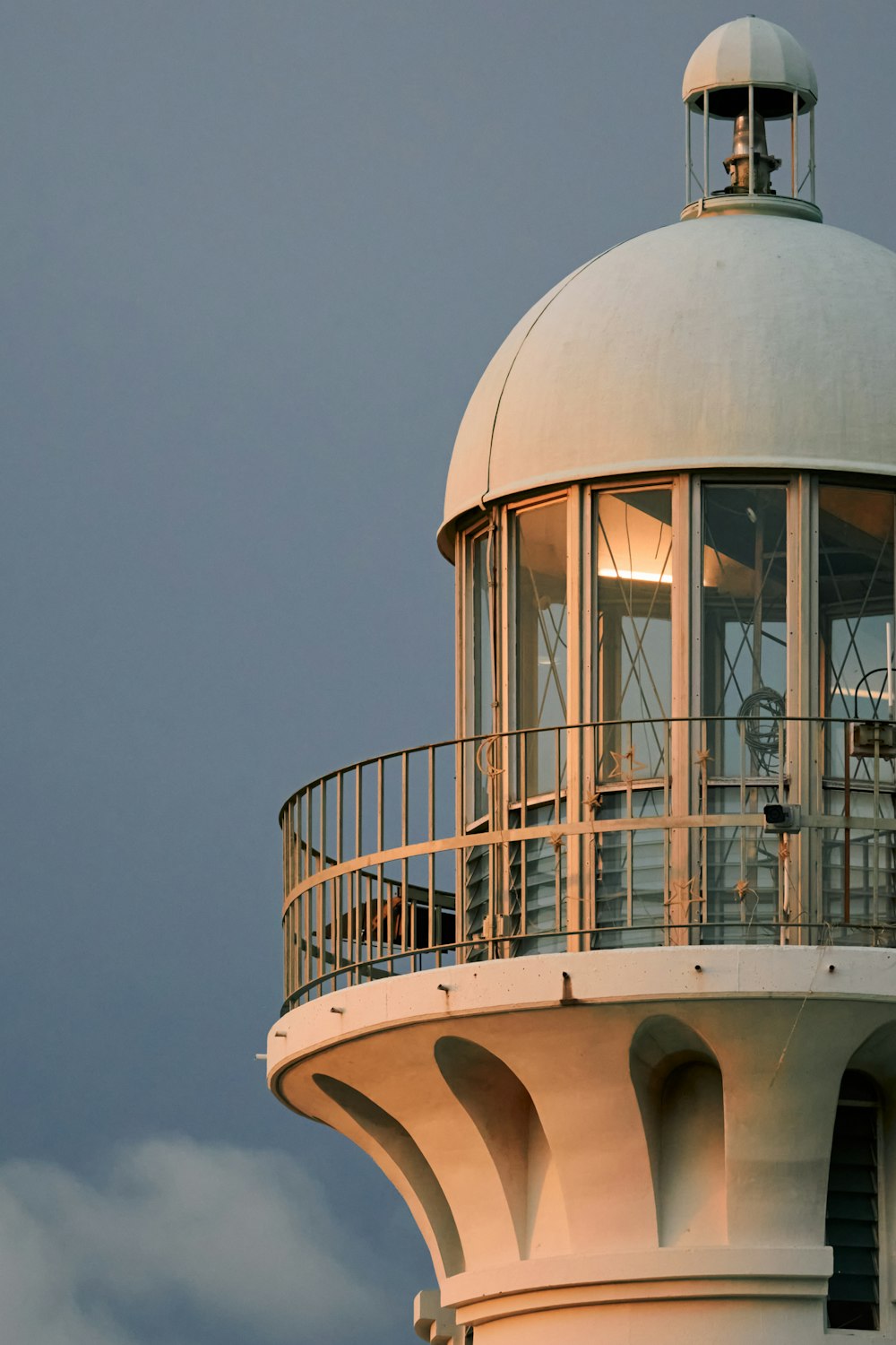 a white lighthouse with a clock on the top of it