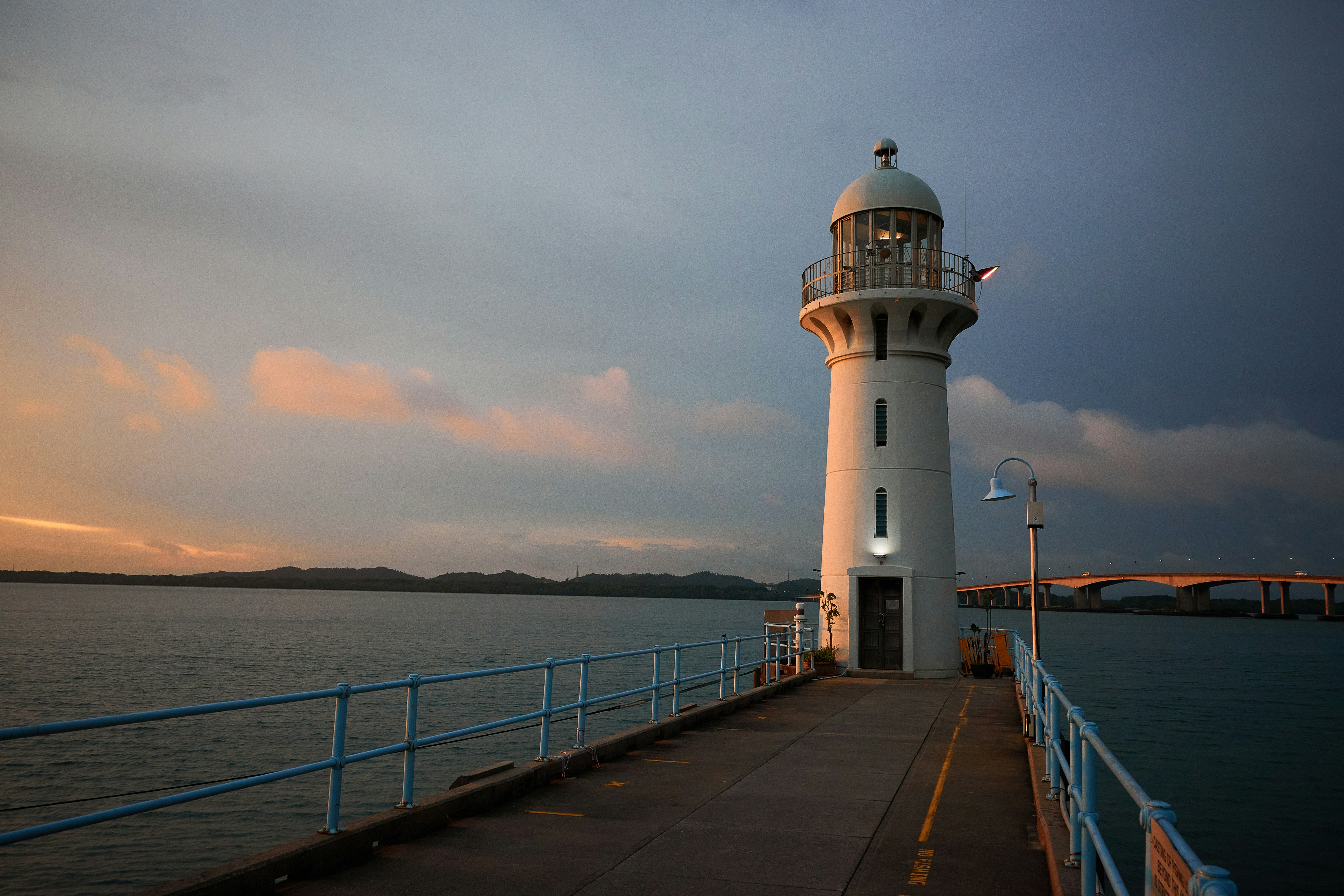 a light house sitting on top of a pier next to the ocean