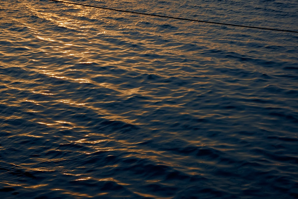 a boat is sailing in the ocean at sunset